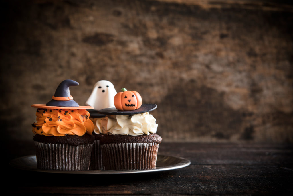 Funny cup cakes as Halloween decoration on the wooden background,selective focus and blank space