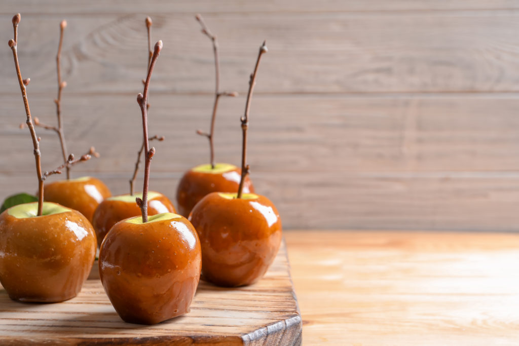 Delicious green caramel apples on table