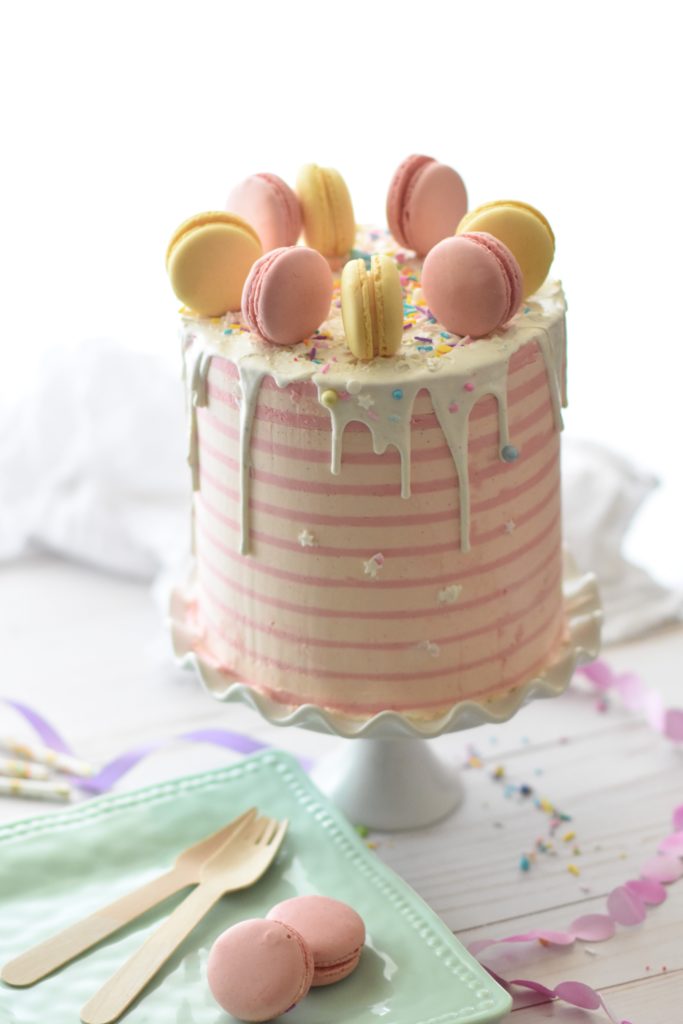 white chocolate drip cake with macarons