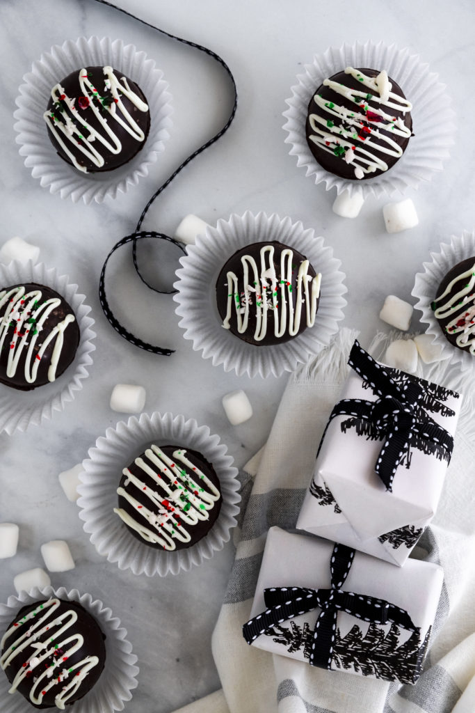 Hot Chocolate bombs on white marble background. Black and white holiday theme.