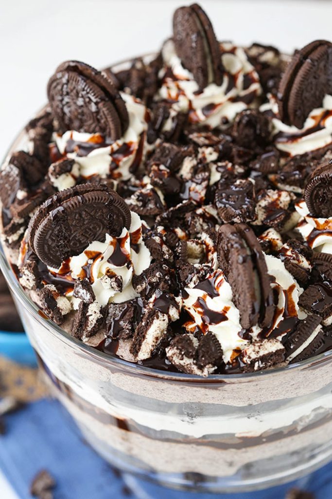 Picture of a top view oreo brownie trifle, decorated with chocolate sauce, whipped cream and halved oreos