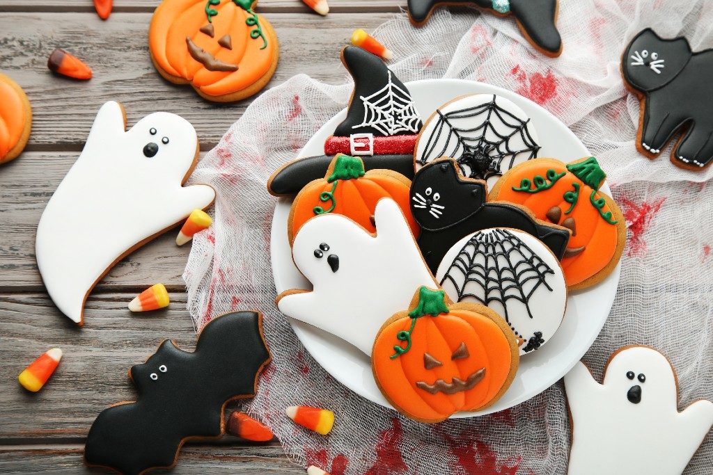 Selection of halloween cookies: ghost, pumpkin, bats, cats, and spider webs, Decorated with Sugarpaste, in white, orange, black and green sugarpaste.